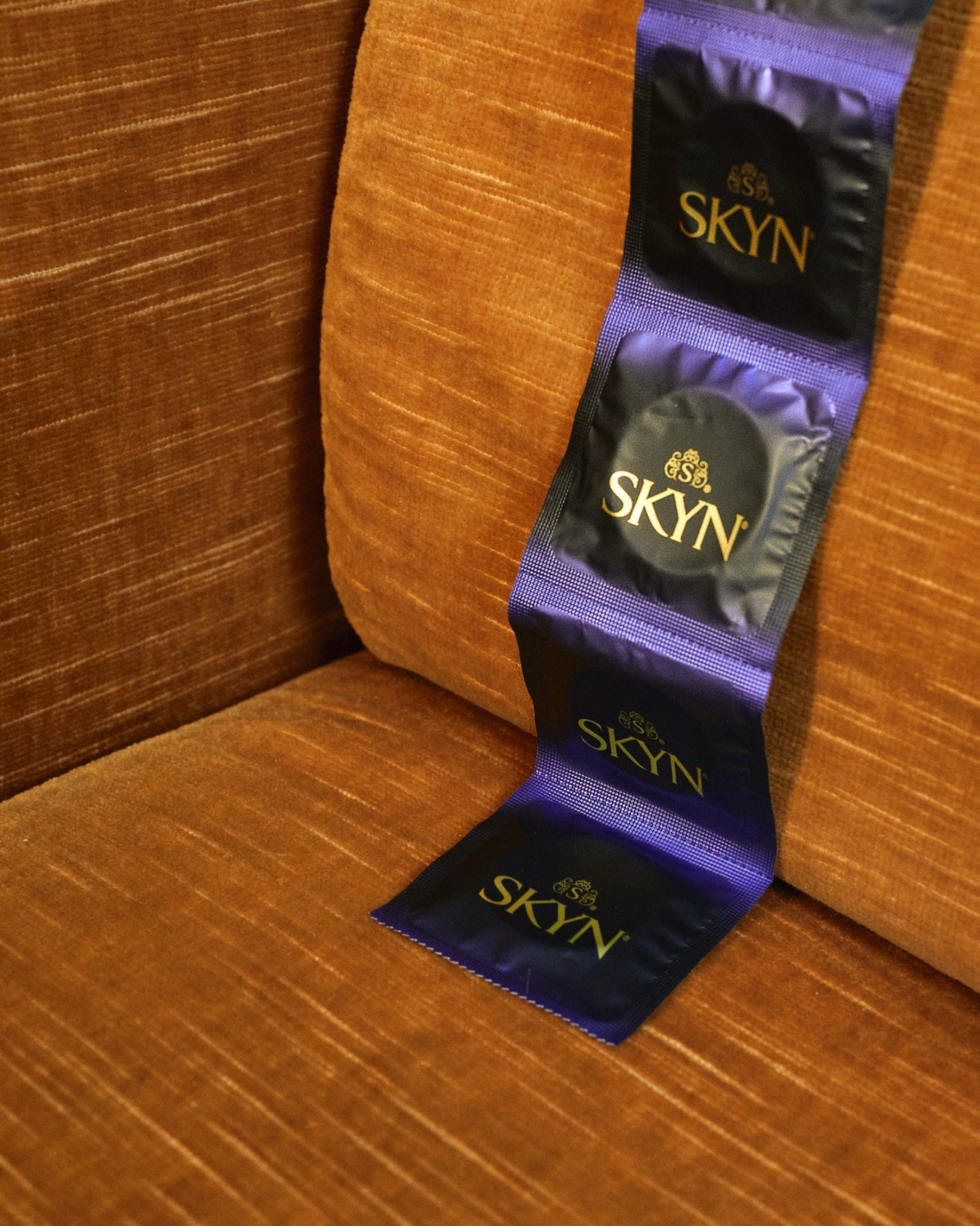 Strip of SKYN condoms over a sofa