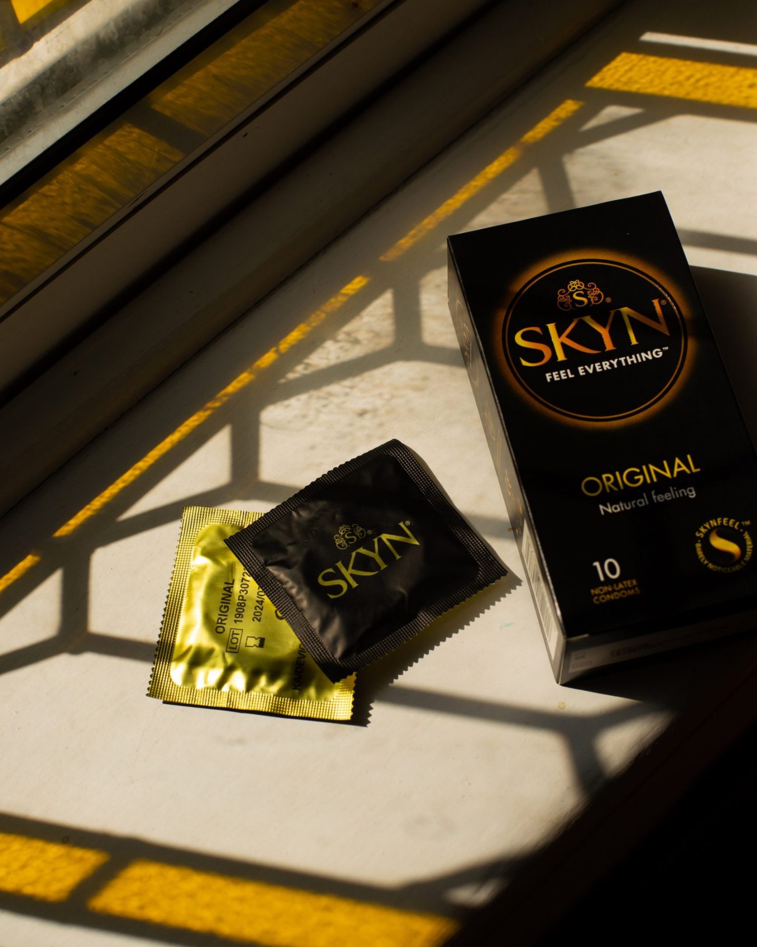 Box of SKYN Original condoms and two condom sleeves