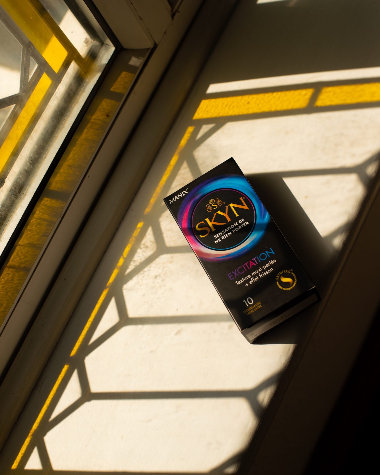 SKYN Excitation condom box under a window